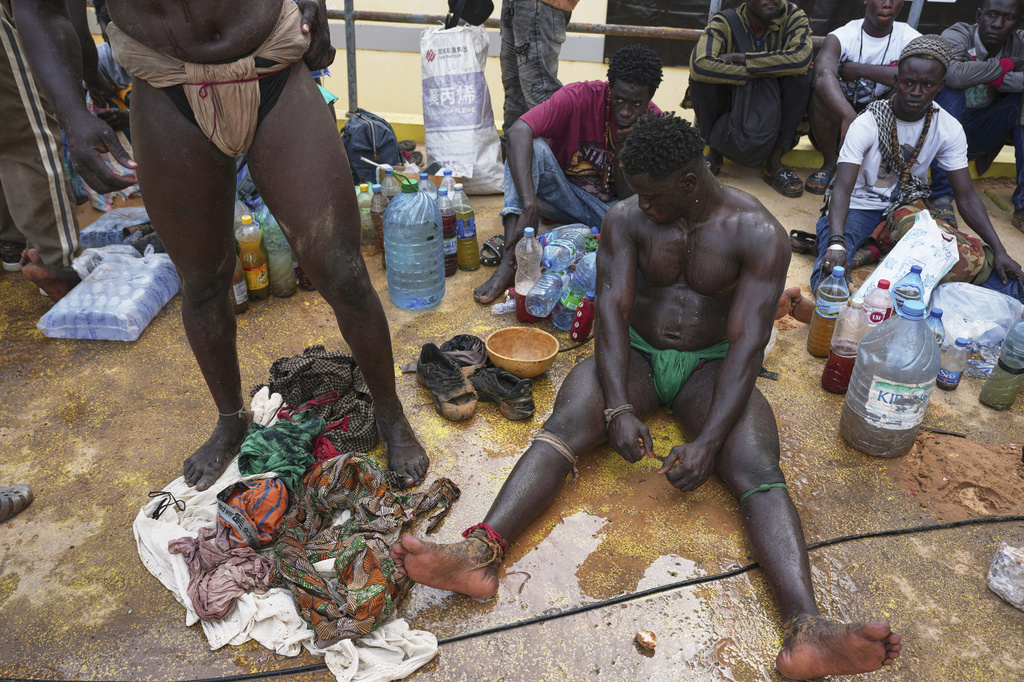 Wrestlers rest after competing at the national arena in Dakar, Senegal, Sunday, March 29, 2026. (AP Photo/Misper Apawu)