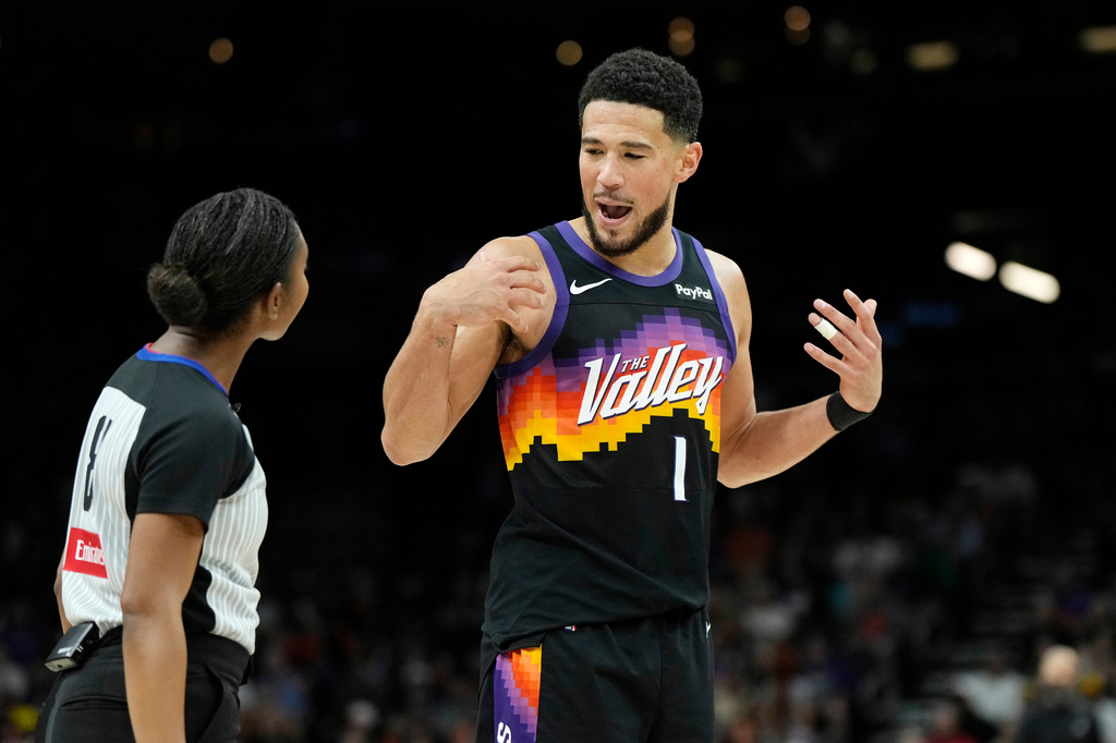 Phoenix Suns guard Devin Booker (1) talks with referee Danielle Scott during the second half of an NBA basketball game against the Dallas Mavericks, Wednesday, April 8, 2026, in Phoenix. (AP Photo/Ross D. Franklin)