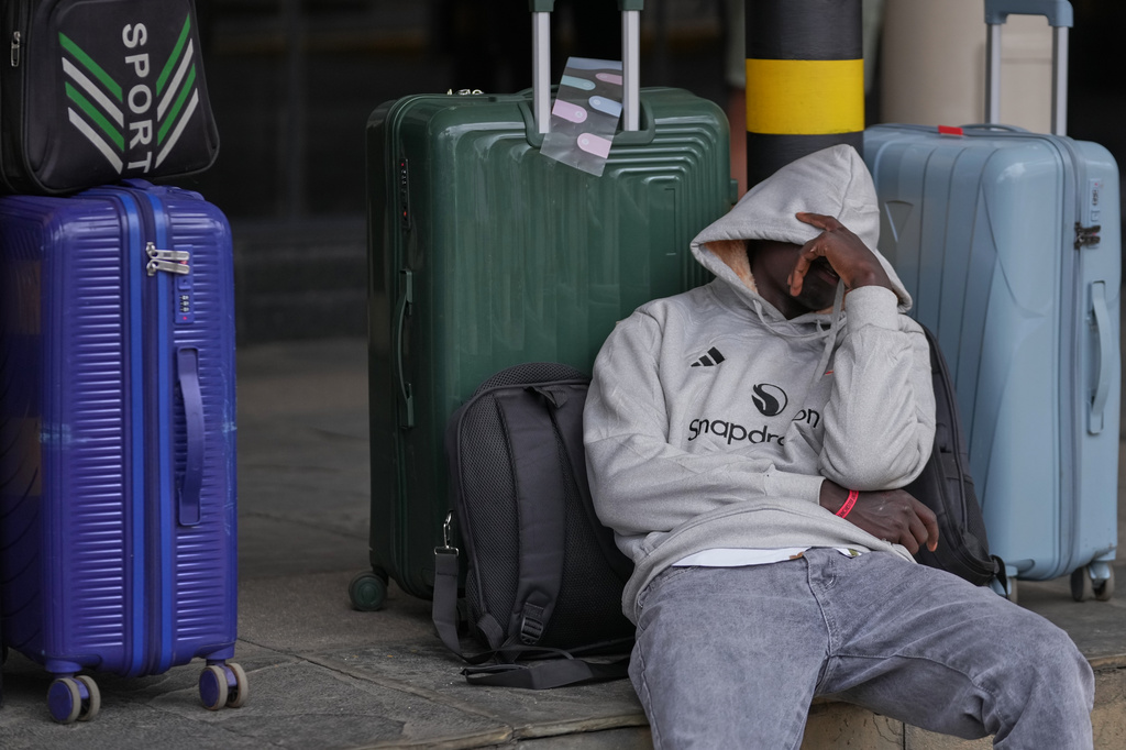 A passenger sleeps as he waits for his delayed flight during a workers strike at Jomo Kenyatta International Airport in Nairobi, Kenya, Monday, Aug. 31, 2026. (AP Photo/Brian Inganga)