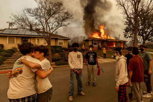 FILE - Residents embrace outside of a burning property as the Eaton Fire swept through Jan. 8, 2025, in Altadena, Calif. (AP Photo/Ethan Swope, File) FILE - Residents embrace outside of a burning property as the Eaton Fire swept through Jan. 8, 2025, in Altadena, Calif. (AP Photo/Ethan Swope, File)