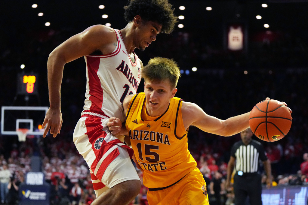 Arizona State guard Noah Meeusen (15) drives on Arizona forward Koa Peat during the first half of an NCAA college basketball game, Wednesday, Jan. 14, 2026, in Tucson, Ariz. (AP Photo/Rick Scuteri)