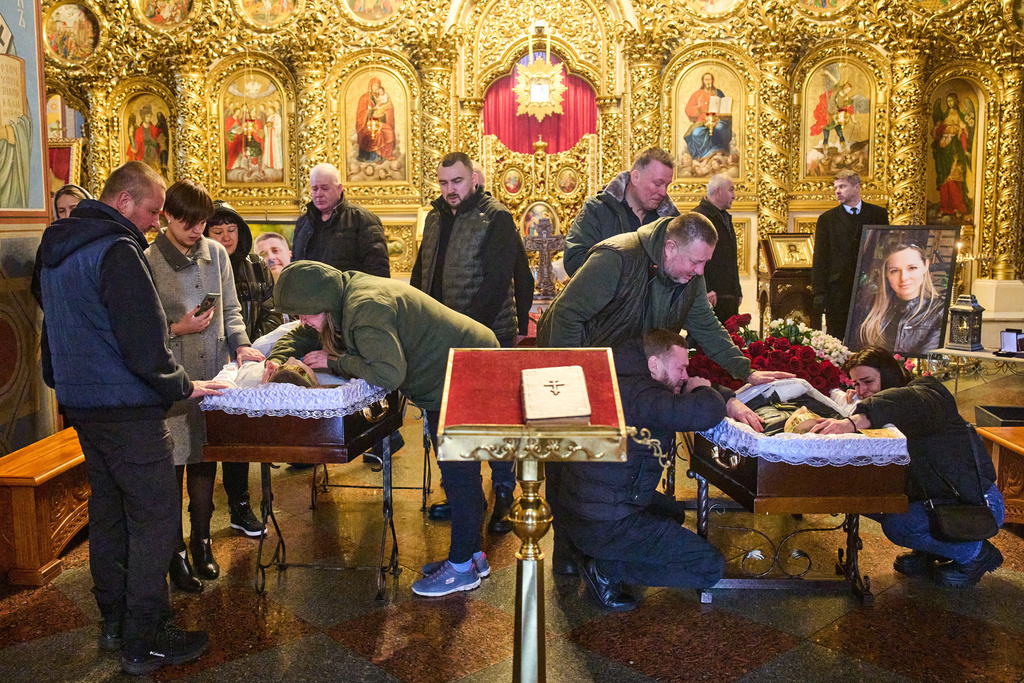 Relatives, colleagues and friends of two Ukrainian 43-year-old journalists Olena Hubanova, who worked under the pseudonym Alyona Gramova, and cameraman Yevhen Karmazin, who were killed on Thursday, Oct. 23, when a Russian Lancet drone hit their vehicle in Ukraine's Kramatorsk around 20 kilometres from the front line, mourn over their coffins during a funeral service at St. Michael Monastery in Kyiv, Ukraine, Monday, Oct. 27, 2025. (AP Photo/Efrem Lukatsky)