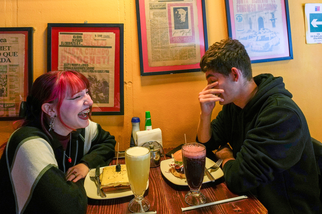 FILE - A couple sit in a cafe in Santiago, Chile, on Nov. 6, 2025. (AP Photo/Esteban Felix, File)