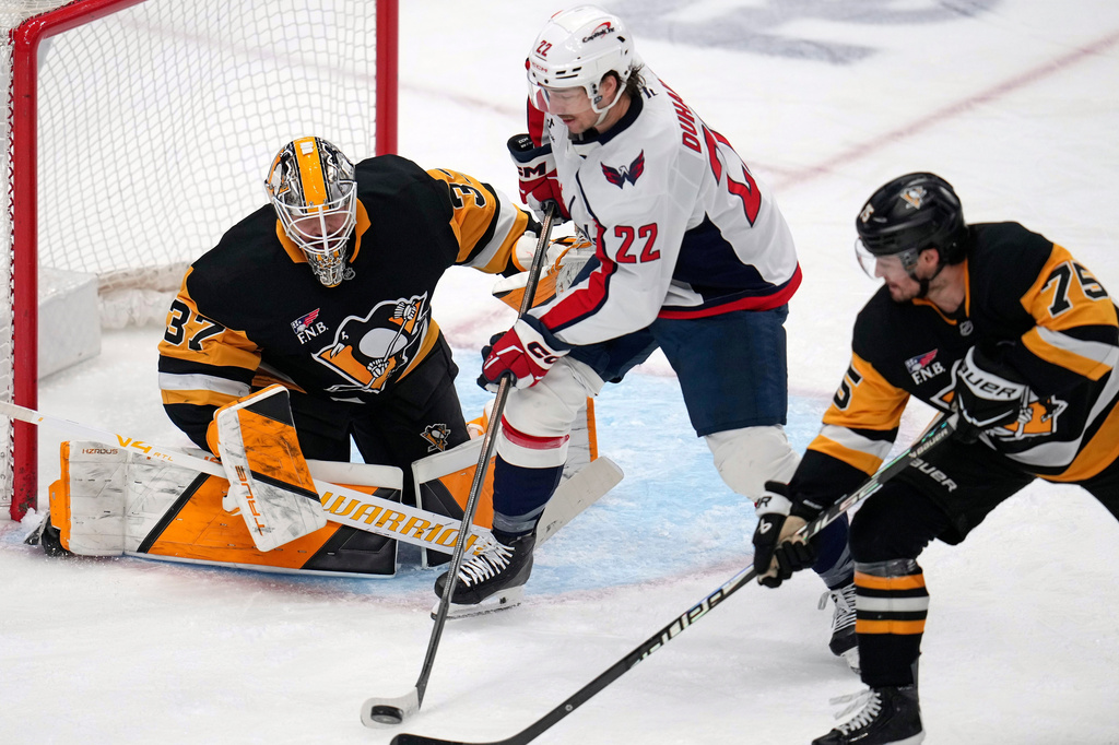 Washington Capitals' Brandon Duhaime (22) can't get off a shot in front of Pittsburgh Penguins goaltender Arturs Silovs (37) with Connor Clifton (75) defending during the first period of an NHL hockey game in Pittsburgh, Saturday, April 11, 2026. (AP Photo/Gene J. Puskar)