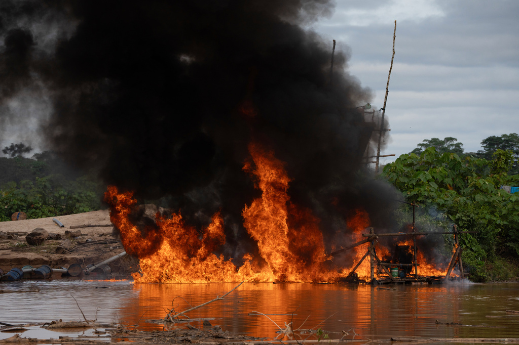 Members of the Peruvian Navy destroy a dredge used for illegal mining near the Malinowski River in the Tambopata National Reserve in Puerto Maldonado, Peru, Tuesday, Aug. 11, 2026. (AP Photo/Guadalupe Pardo)