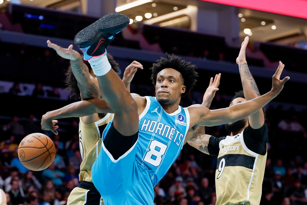 Charlotte Hornets guard Collin Sexton (8) passes behind him during the first half of an NBA basketball game against the Washington Wizards in Charlotte, N.C., Tuesday, Dec. 23, 2025. (AP Photo/Nell Redmond)