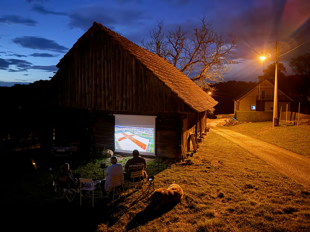 Locals watch the World Cup soccer match between England and Croatia projected on the barn wall, in Kumrovec, northern Croatia, Wednesday, June 17, 2026. (AP Photo/Darko Bandic)