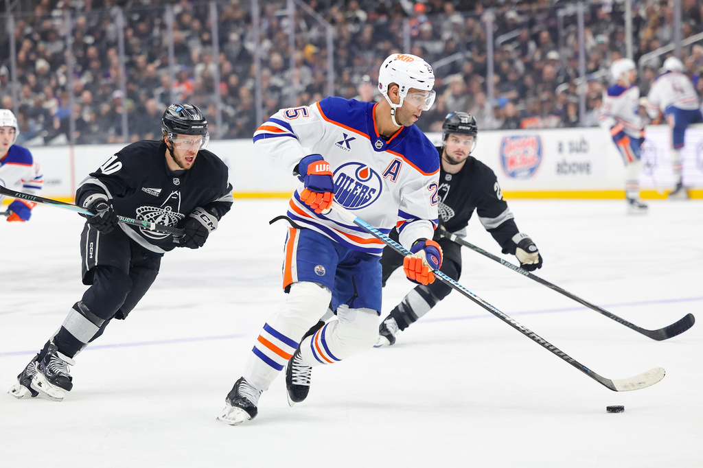 FILE - Edmonton Oilers defenseman Darnell Nurse, center front, moves the puck against Los Angeles Kings left wing Artemi Panarin, left, and center Scott Laughton, right, during the first period of an NHL hockey game, April 11, 2026, in Los Angeles. (AP Photo/Ryan Sun, File)