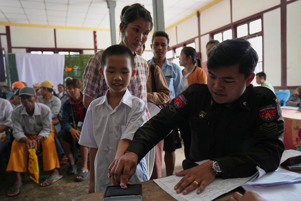 In this photo taken during a trip supervised by pro-military Myanmar media, an Immigration officer notes personal data of locals for lost and damaged national registration cards, at their temporary office, in Kyaukme, northern Shan State, Myanmar, Friday, Oct. 10, 2025. (AP Photo/Aung Shine Oo)