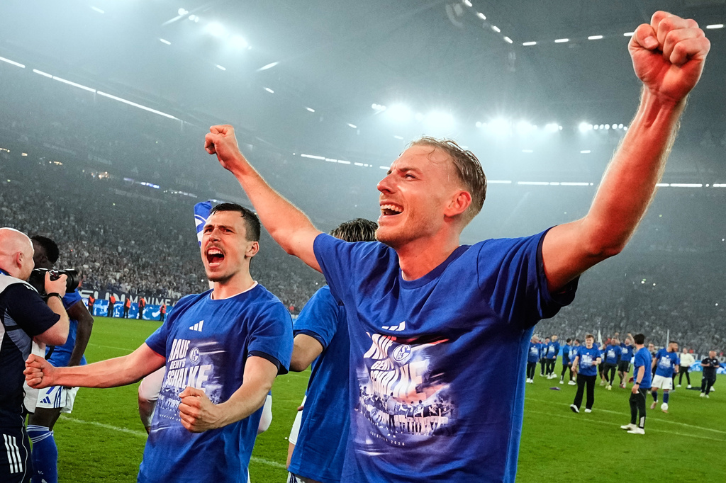 Schalke's Timo Becker and Schalke's Ron Schallenberg celebrate after FC Schalke 04 secured promotion to the German Bundesliga by winning the Bundesliga 2 match against Fortuna Duesseldorf at the Arena in Gelsenkirchen, Germany, Saturday, May 2, 2026. (AP Photo/Martin Meissner)