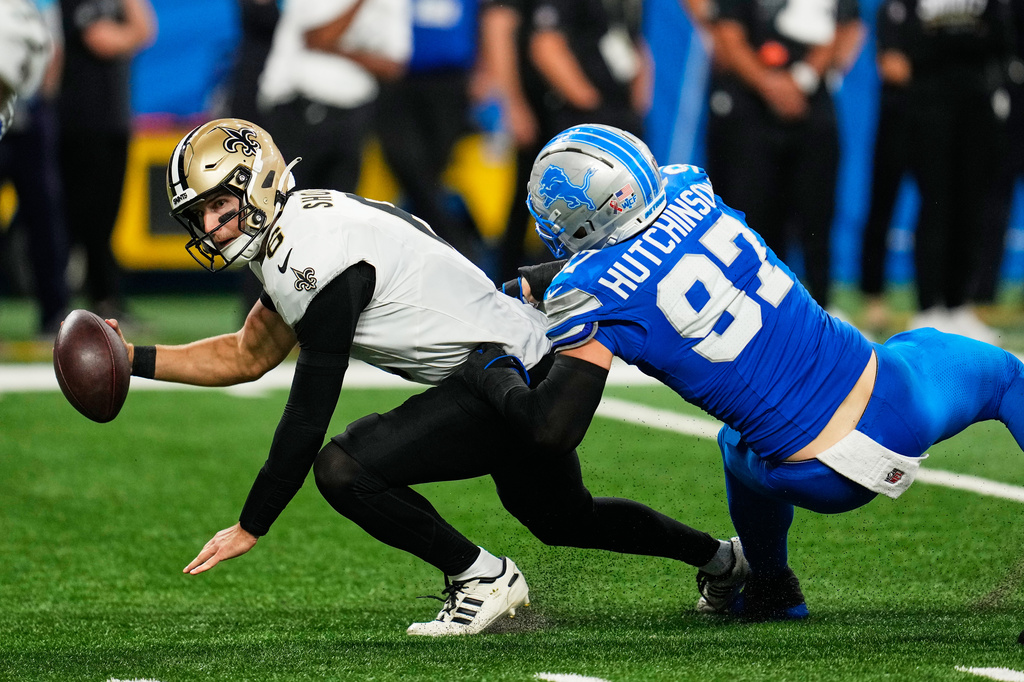 New Orleans Saints quarterback Tyler Shough (6) is sacked by Detroit Lions defensive end Aidan Hutchinson (97) in the second half of an NFL football game, Sunday, Sept. 13, 2026, in Detroit.(AP Photo/Paul Sancya)