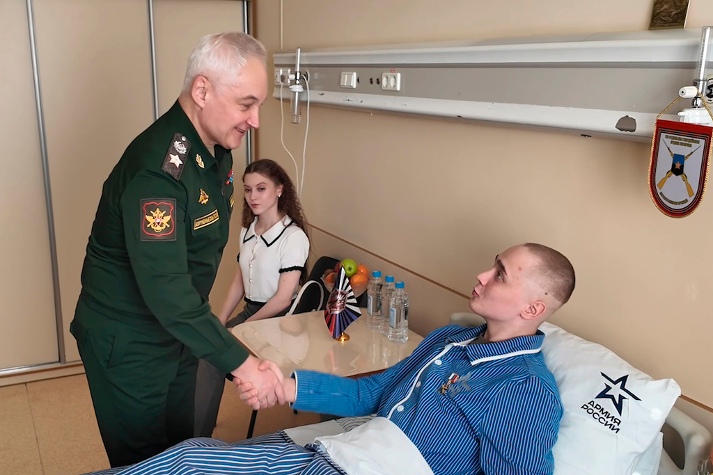 In this image made from video provided by Russian Defense Ministry Press Service on Tuesday, March 24, 2026, Russian Minister of Defense Andrei Belousov, left, presents the "Gold Star" Hiro of Russia medal to a participant of the military action in Ukraine, Private Sergei Yarashev, at The National Medical Research Center of Surgery in Moscow. (Russian Defense Ministry Press Service via AP)