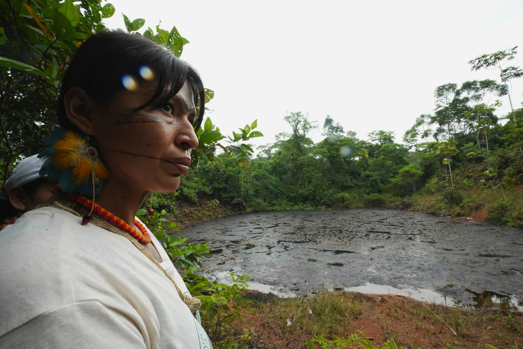 Toa Alvarado, a Kichwa leader, listens as activists explain the environmental damage caused by oil extraction while visiting the contaminated areas in Sucumbios, Ecuador, Friday, March 6, 2026. (AP Photo/Dolores Ochoa)